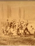 Notman composite photo of McGill-Harvard Football game, Mt. Royal in background, scrimmage scene. The Harvard players are on the left and the McGill players on the right in red and white striped sweaters. (photo 1874). MUA PL007034.
