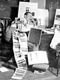 Saul Hayes, editor-in-chief of Old McGill, speaks on phone at littered desk. (photo 1932). MUA PU038136.