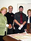 From left: Associate Secretary-General and University Archivist Johanne Pelletier, Waste Management Program manager Claude Lahaie, McGill Campus Security officer Sergeant Mathieu Racette, and Director of Security Louise Savard gather around the opened time capsule, its contents on display on the table. Photo by David Kemper/McGill University Archives.